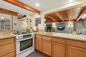 una cocina con estufa y fregadero en WSH1030 - Camp Westwater home, en Tahoma 33 fotos más