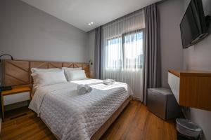 a bedroom with a bed with two towels on it at King Hotel Ksamil in Ksamil