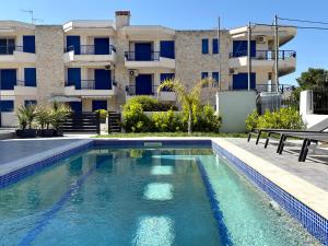 a swimming pool in front of a building at PLATINUM apartment with pool in Kallithea Halkidikis