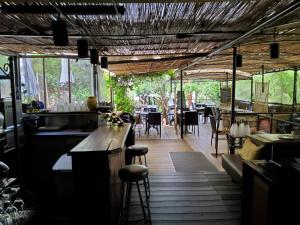 Un restaurante con un bar y una mesa y sillas. en Le Tempo, en Entrecasteaux
