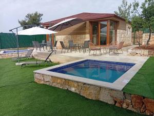 a swimming pool in a yard with chairs and an umbrella at Casa del mir in Dayr al Qamar