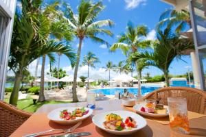 a table with plates of food next to a pool at ANA InterContinental Manza Beach Resort by IHG in Onna