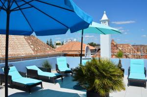 a group of chairs and umbrellas on a patio at Tavira House in Tavira