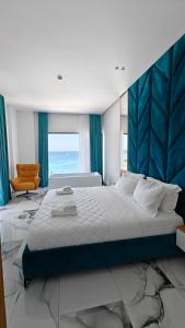 a bedroom with a large bed and an orange chair at King Hotel Ksamil in Ksamil