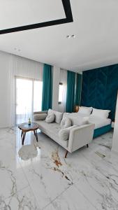 a living room with a white couch and a table at King Hotel Ksamil in Ksamil