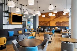 a waiting room with tables and chairs and a tv at Four Points Flex by Sheraton Koblenz in Koblenz