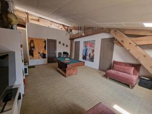 a living room with a pool table and a couch at L'escapade colorée anciennement La Vieille Forge in Rieux-Minervois