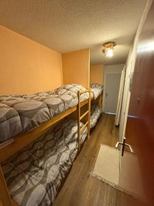 オルシエールにあるAppartement avec balcon 6 couchagesの二段ベッド2台とドアが備わる客室です。