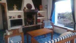 a living room with a table and chairs and a fireplace at Villa Exclusiva en El Hierro con Piscina Privada in Las Puntas