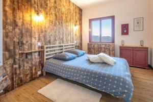 a bedroom with a bed and a wooden wall at Le Grand Som - Proche Station de ski in Saint-Pierre-de-Chartreuse