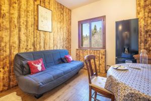 a living room with a blue couch and a table at Le Grand Som - Proche Station de ski in Saint-Pierre-de-Chartreuse