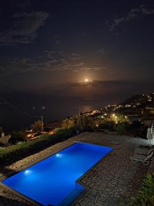 a blue swimming pool at night with a view at Veranda Blue in Nikiana