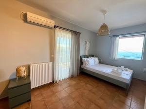 a bedroom with a bed and a large window at Veranda Blue in Nikiana +14 photos