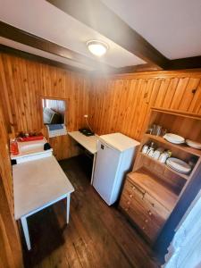 a small kitchen with a refrigerator and a table at Domek Okonin in Elgiszewo