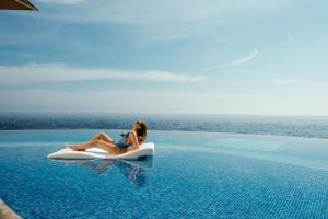 a woman sitting on a raft in a swimming pool at 1926 Les Bains Private Spa Suites in Sliema +36 photos