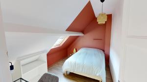 a small attic bedroom with red walls and a white bed at Magnifique maison avec Jardin in Le Havre