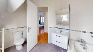 a white bathroom with a toilet and a sink at Magnifique maison avec Jardin in Le Havre