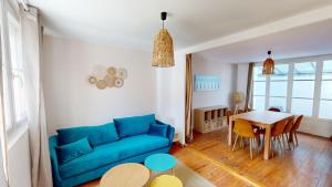 a living room with a blue couch and a table at Magnifique maison avec Jardin in Le Havre