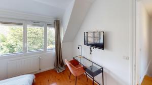 a bedroom with a bed and a tv on a wall at Magnifique maison avec Jardin in Le Havre
