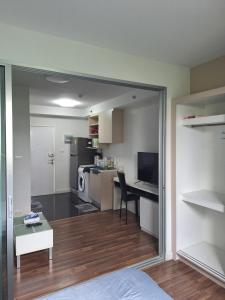 a room with a bed and a desk and a kitchen at Mari Space in Nonthaburi