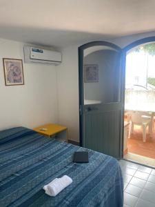Un dormitorio con una cama y una puerta a un patio. en villa Macari, en San Vito lo Capo