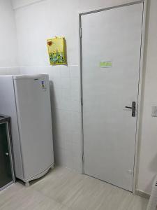 Apartamento Praia Bela Vista في انغرا دوس ريس: باب أبيض في غرفة بها ثلاجة