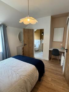 ein Schlafzimmer mit einem Bett und ein Zimmer mit einem Bad in der Unterkunft Luxueux logement proche gare et centre ville in Tourcoing