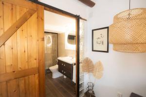 a bathroom with a sink and a toilet and a chandelier at Casa rural Casa Vidosa in Murillo de Gállego +108 photos