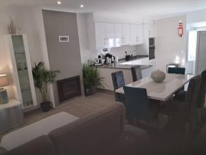 a kitchen and living room with a table and a dining room at My home in Cercal