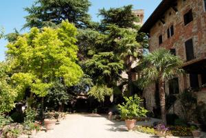 un jardín frente a un edificio con árboles y plantas en Residenza d'Epoca Il Cassero, en Lucignano