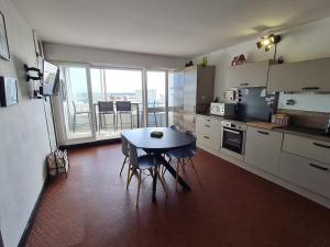 a kitchen with a table and a table and chairs at Chez Bruno in Saint-Jean-de-Monts +17 photos