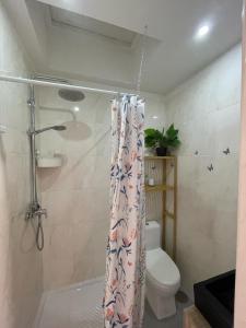a bathroom with a shower curtain with a toilet at Cici Guesthouse in Caminha