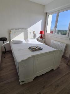 a white bed in a room with a window at Chez Bruno in Saint-Jean-de-Monts