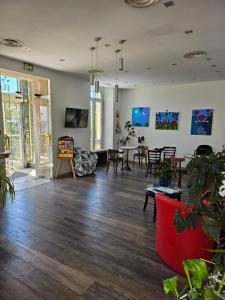 a living room with wooden floors and tables and chairs at Hotel Flots d'Azur Promenade des Anglais in Nice