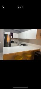 a kitchen with a counter with two stools in it at Luxro Home Crotone in Crotone