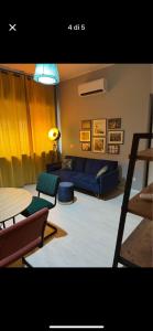 a living room with a blue couch and a table at Luxro Home Crotone in Crotone