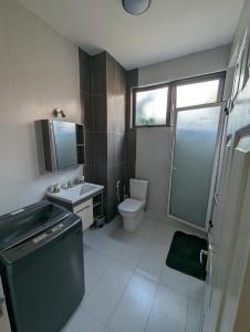 a bathroom with a sink and a toilet and a window at Flic en Flac île Maurice in Flic-en-Flac