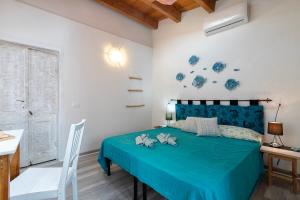 a bedroom with a blue bed with a blue comforter at Domus De Mirto in Sennori