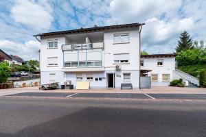 a white building on the side of a street at Ferienwohnungen Golsong in Thaleischweiler-Fröschen