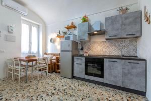 a kitchen with a sink and a table with chairs at Domus De Mirto in Sennori
