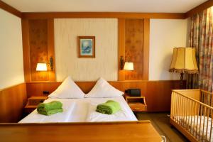 ein Schlafzimmer mit einem Bett, auf dem zwei grüne Handtücher liegen in der Unterkunft Natur & Wander Hotel Gassbachtal in Grasellenbach + 74 Fotos