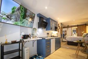 a kitchen with blue cabinets and a bed in a room at Roca Loft Maruja - by Allexperiences in Setenil
