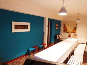 1 dormitorio con 1 cama blanca grande y paredes azules en Wayra Hostel en La Rioja