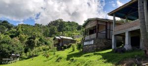 an old building on a grassy hill with trees at Kelimutu View Bungalows in Kelimutu