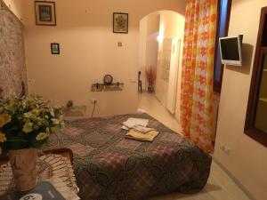 a bedroom with a bed and a vase of flowers at Apartments Aurora Delle Rose in Assisi