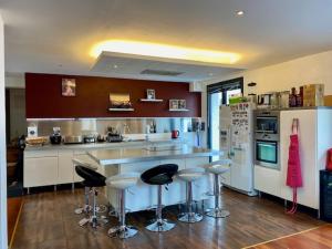 a kitchen with a counter and bar stools in it at Alery Loft in Annecy