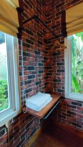 a brick wall with a bench in front of two windows at โอรีสอร์ต Oresort in Ban Chua Phloeng +33 photos