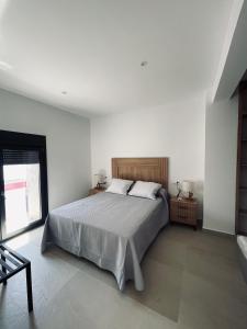 a white bedroom with a bed and a window at La Unión in Solana de los Barros
