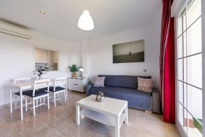 a living room with a blue couch and a table at Campo de golf, piscina y padel in Almería