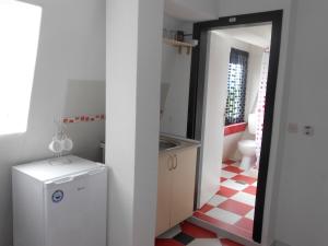 eine Küche mit einem weißen Kühlschrank und einem roten und weißen Boden in der Unterkunft Villa Angel Apartments - OHRID- in Ohrid